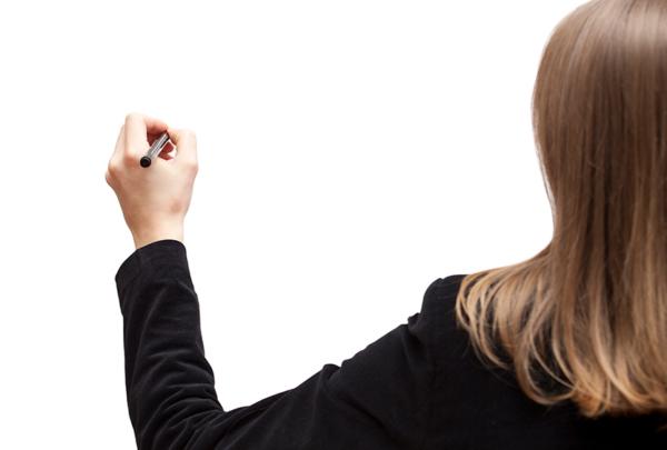 Woman writing on whiteboard.